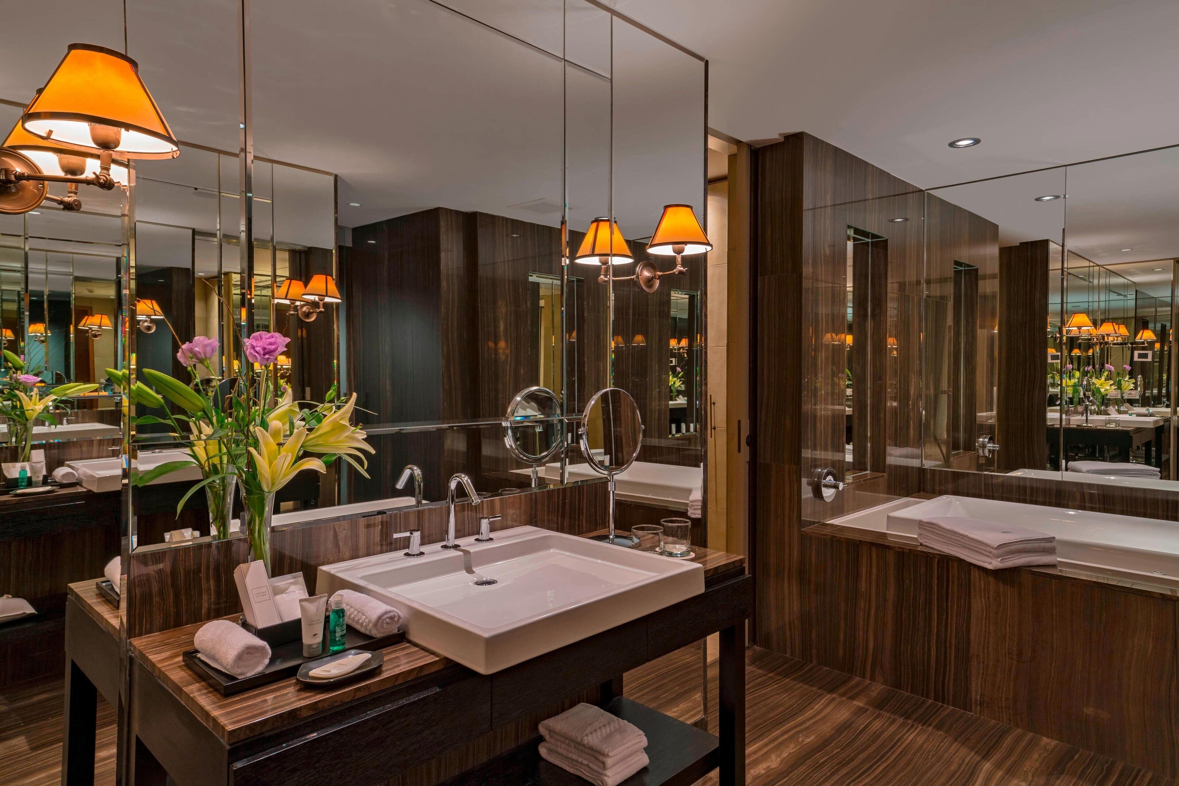 A modern bathroom with a large mirror, a sink, and a vanity.