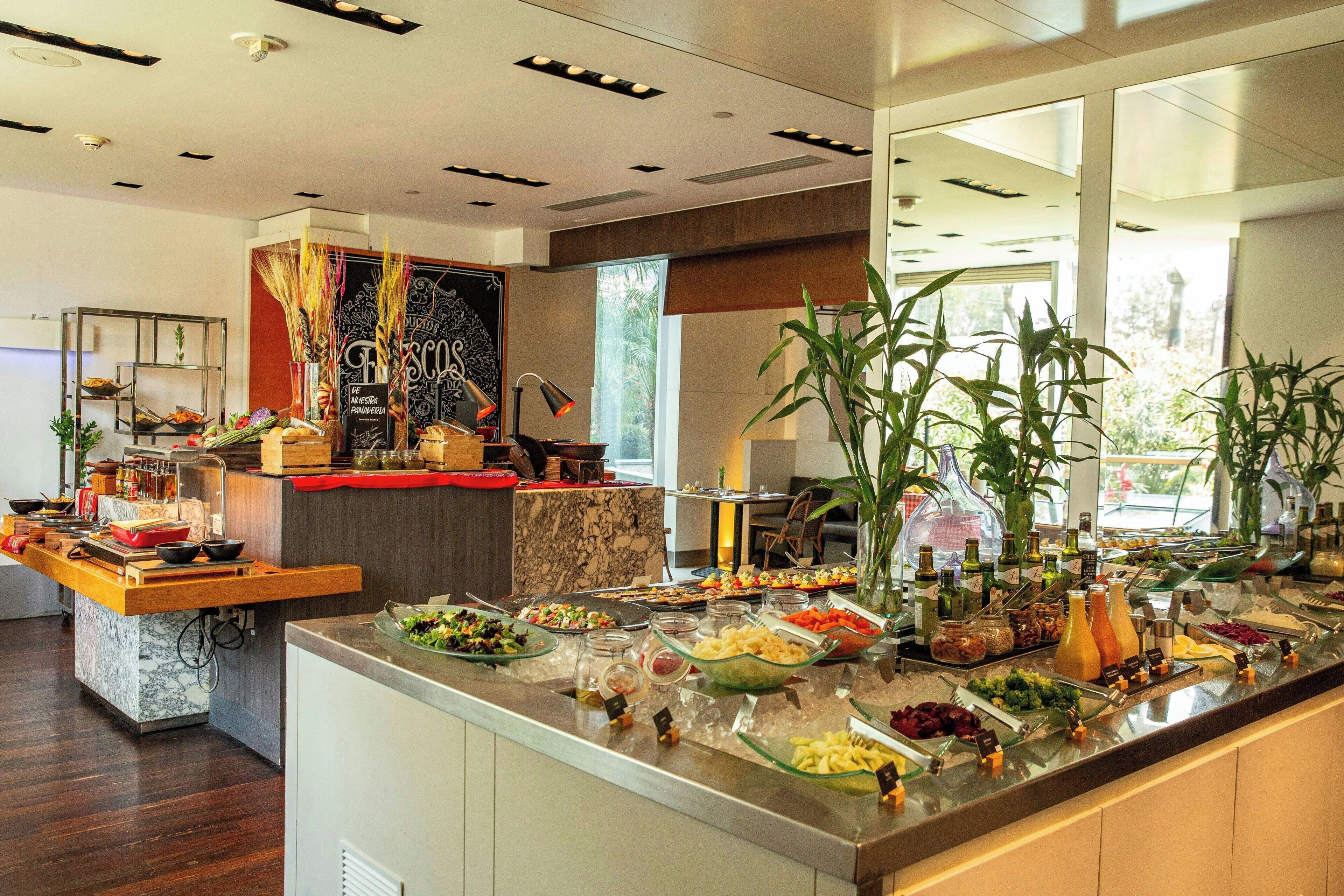 Un bufé con diversos alimentos y una zona de cocina al fondo.