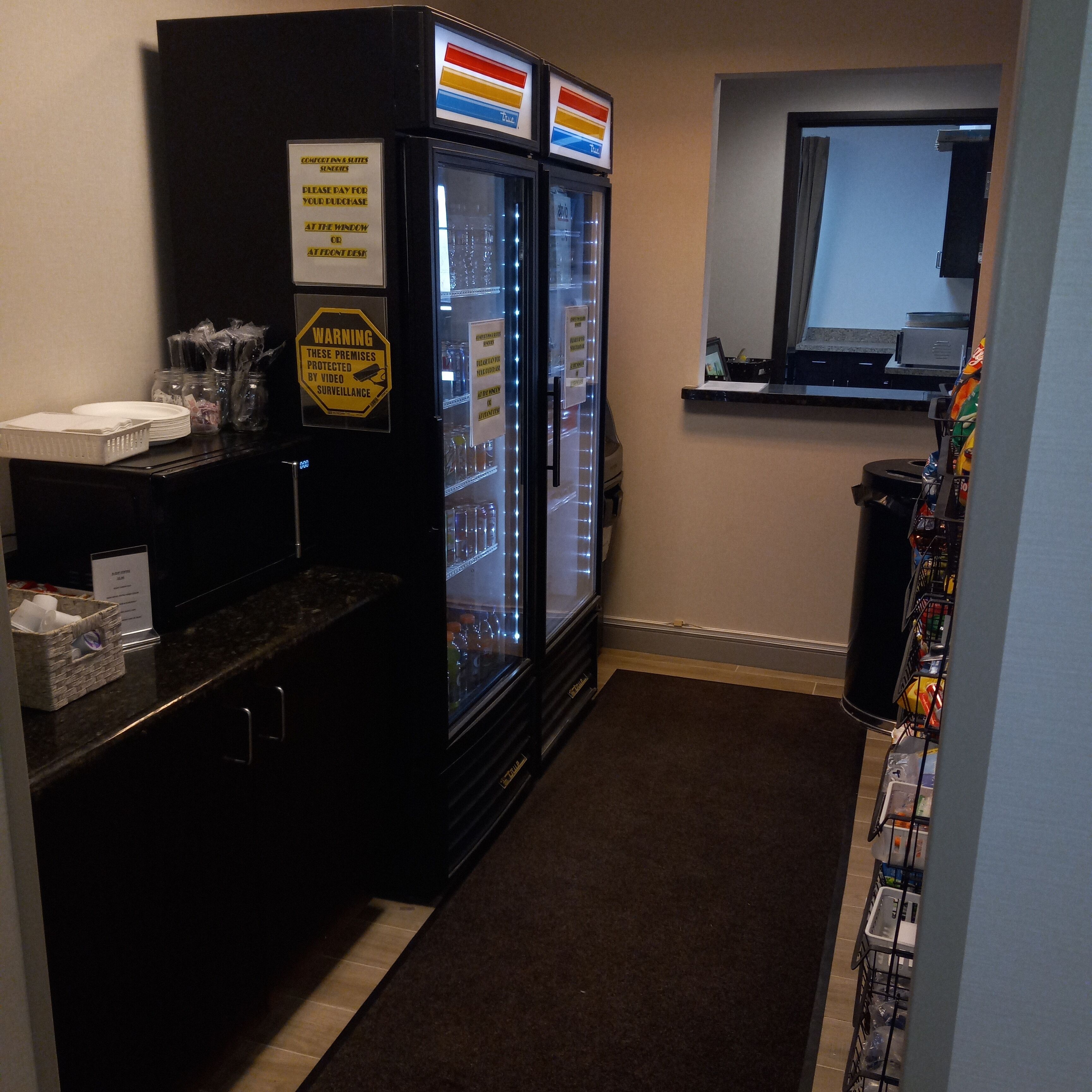 A hotel room with a minibar, a refrigerator, and a window.