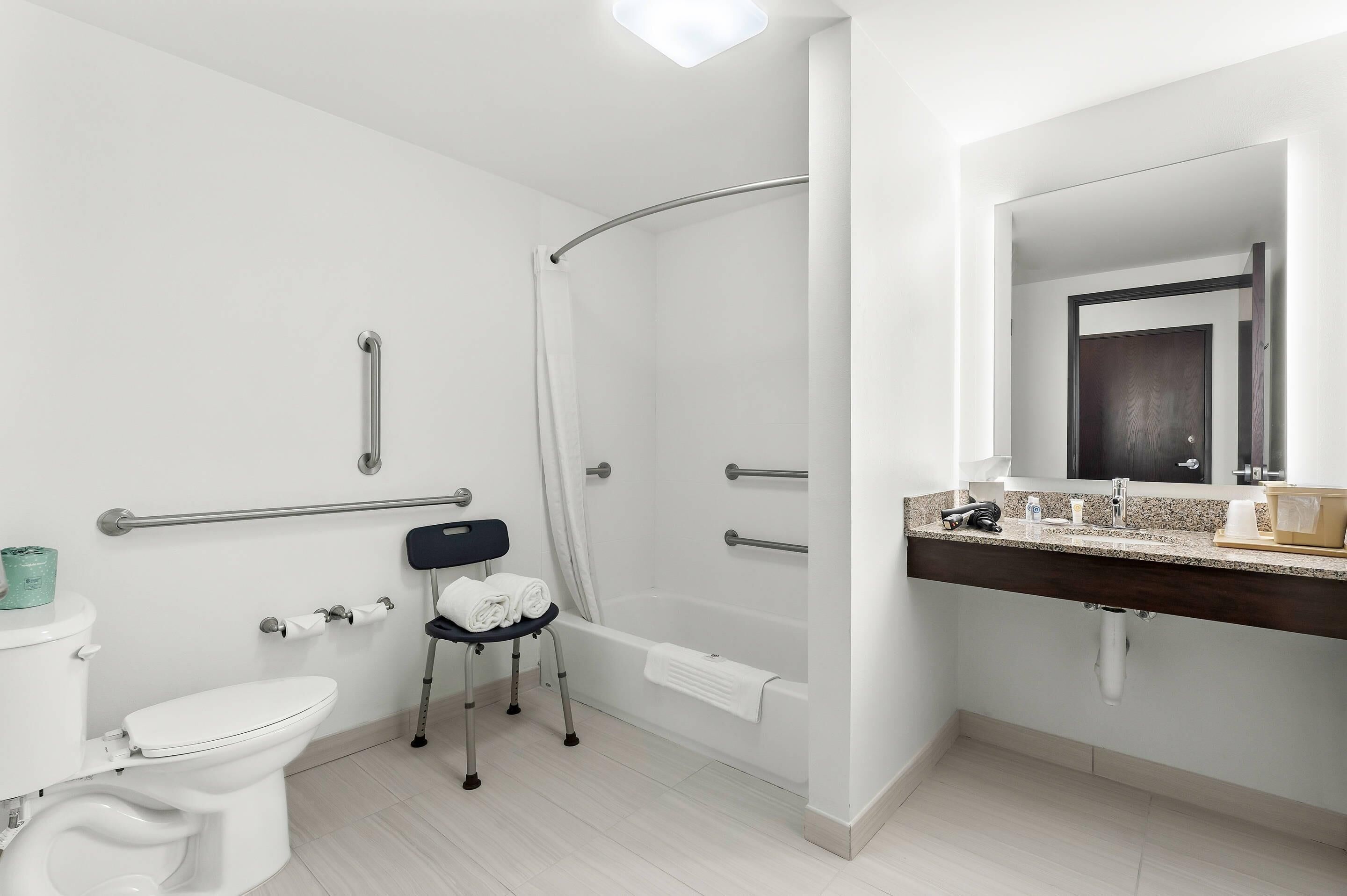 A modern bathroom with a shower, toilet, and sink.