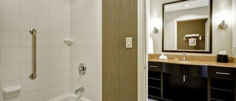 A modern bathroom with a bathtub, a shower, and a vanity with a mirror.