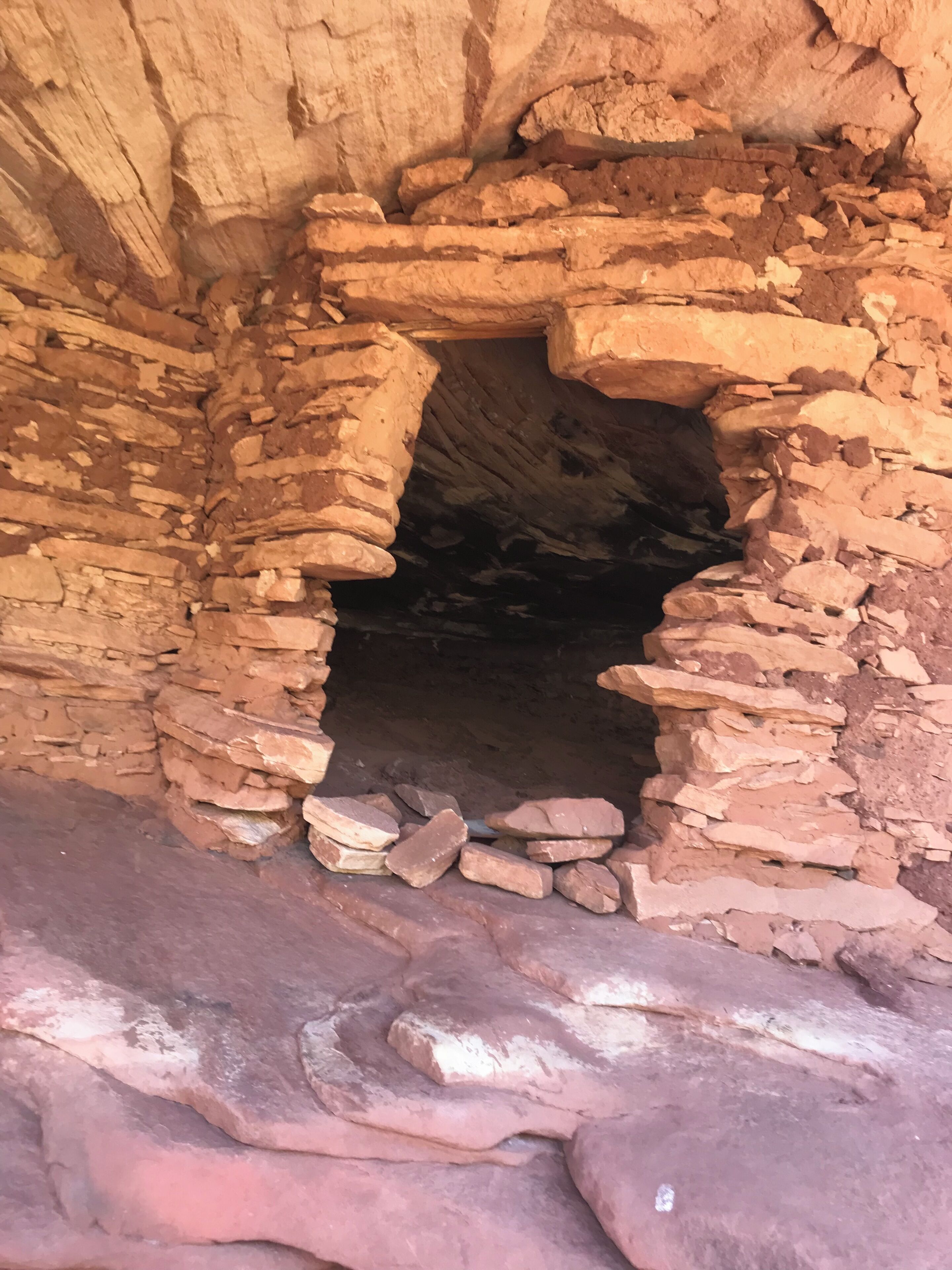 Una construcción de piedra con una abertura estrecha, quizás una cueva o ruina antigua.