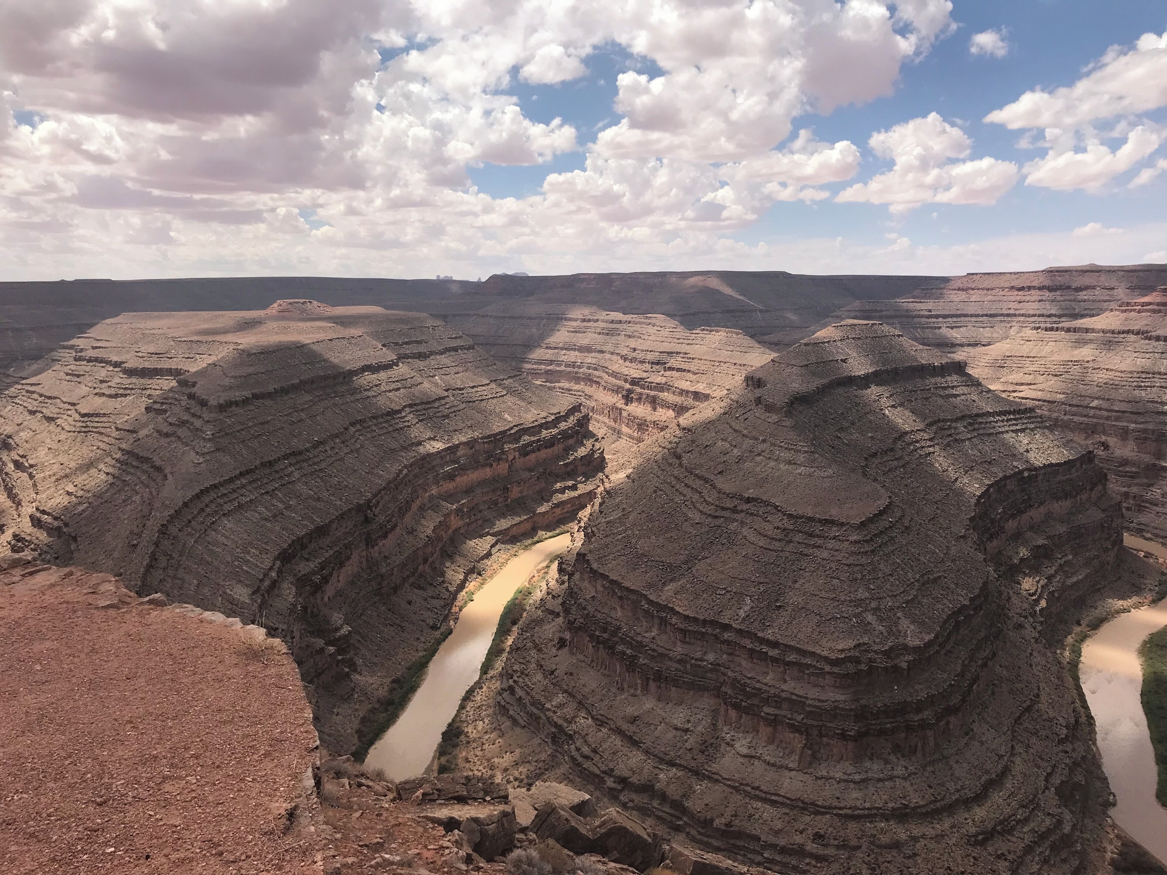 Een canyon met gelaagde rotsformaties en een rivier die erdoorheen stroomt.