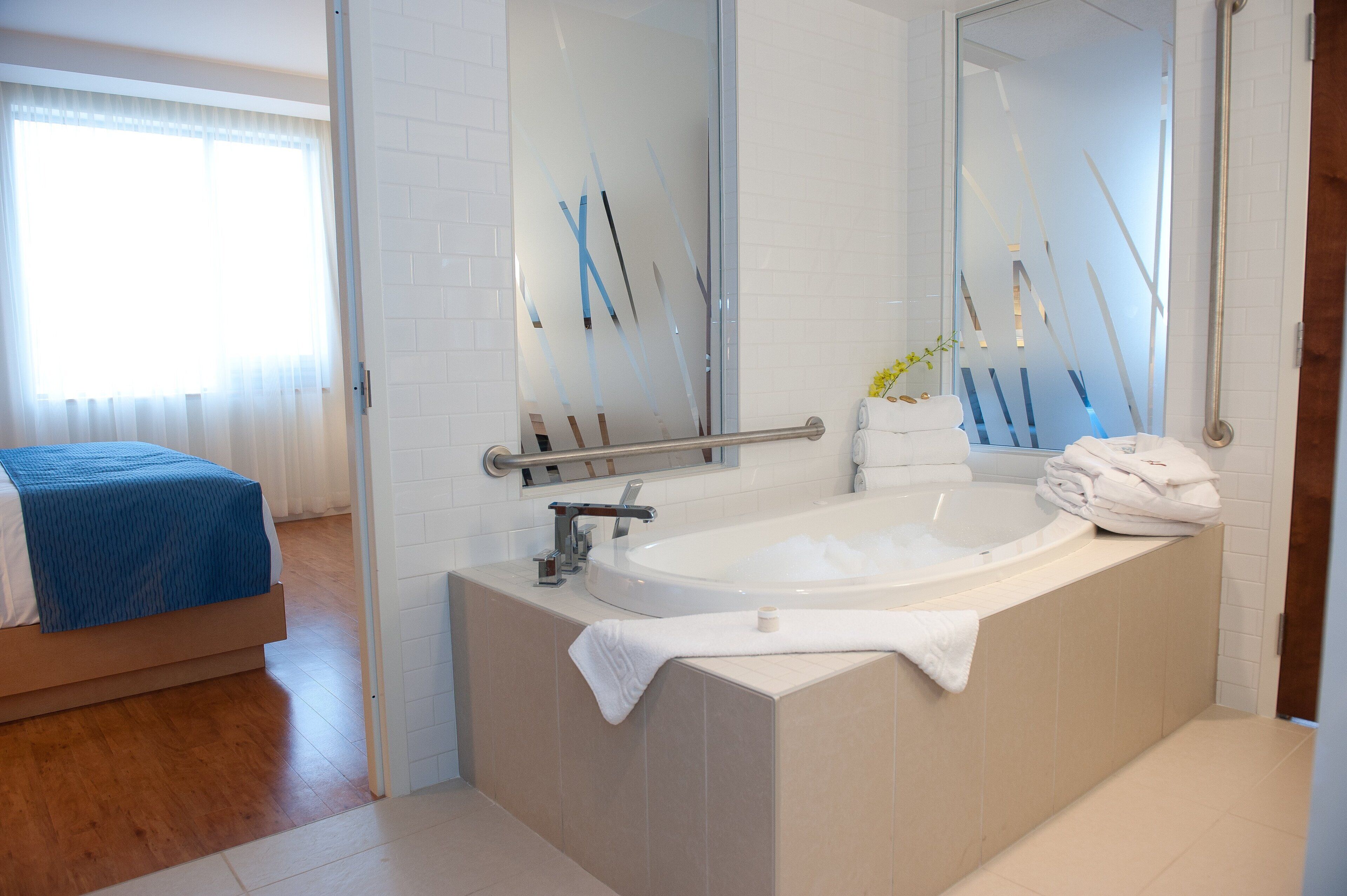 A modern bathroom with a bathtub, a glass shower enclosure, and a visible toilet.