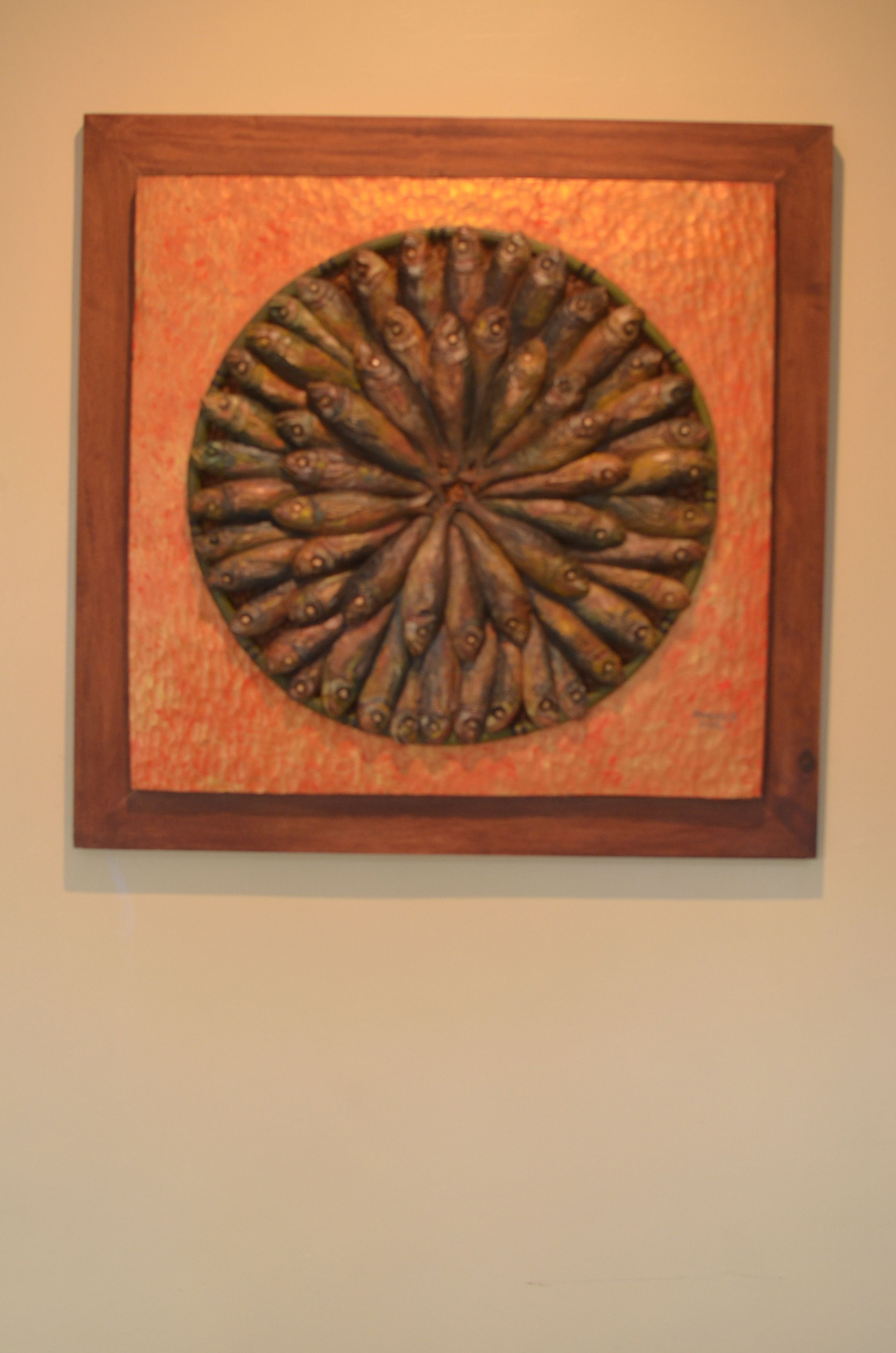 A circular artwork with a central motif surrounded by a square frame.