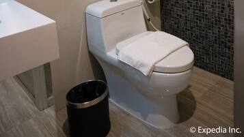 A modern bathroom with a toilet, sink, and a towel rack with two towels.