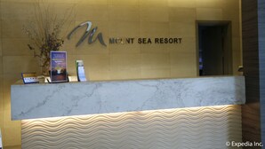 A reception desk at Mount Sea Resort with a marble top and a wavy design at the base.