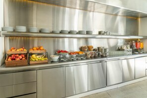 A stainless steel buffet setup with various fruits and condiments. - Dazzler by Wyndham Buenos Aires Recoleta (Buenos Aires)
