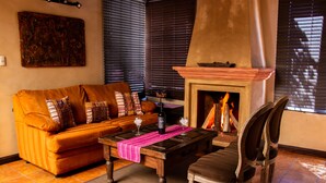 Una sala de estar acogedora con chimenea, un sofá, una mesa de centro y un sillón.