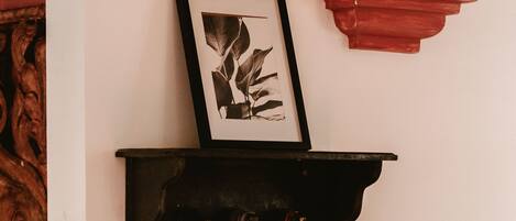 A wall-mounted shelf with a framed picture and decorative tassels.