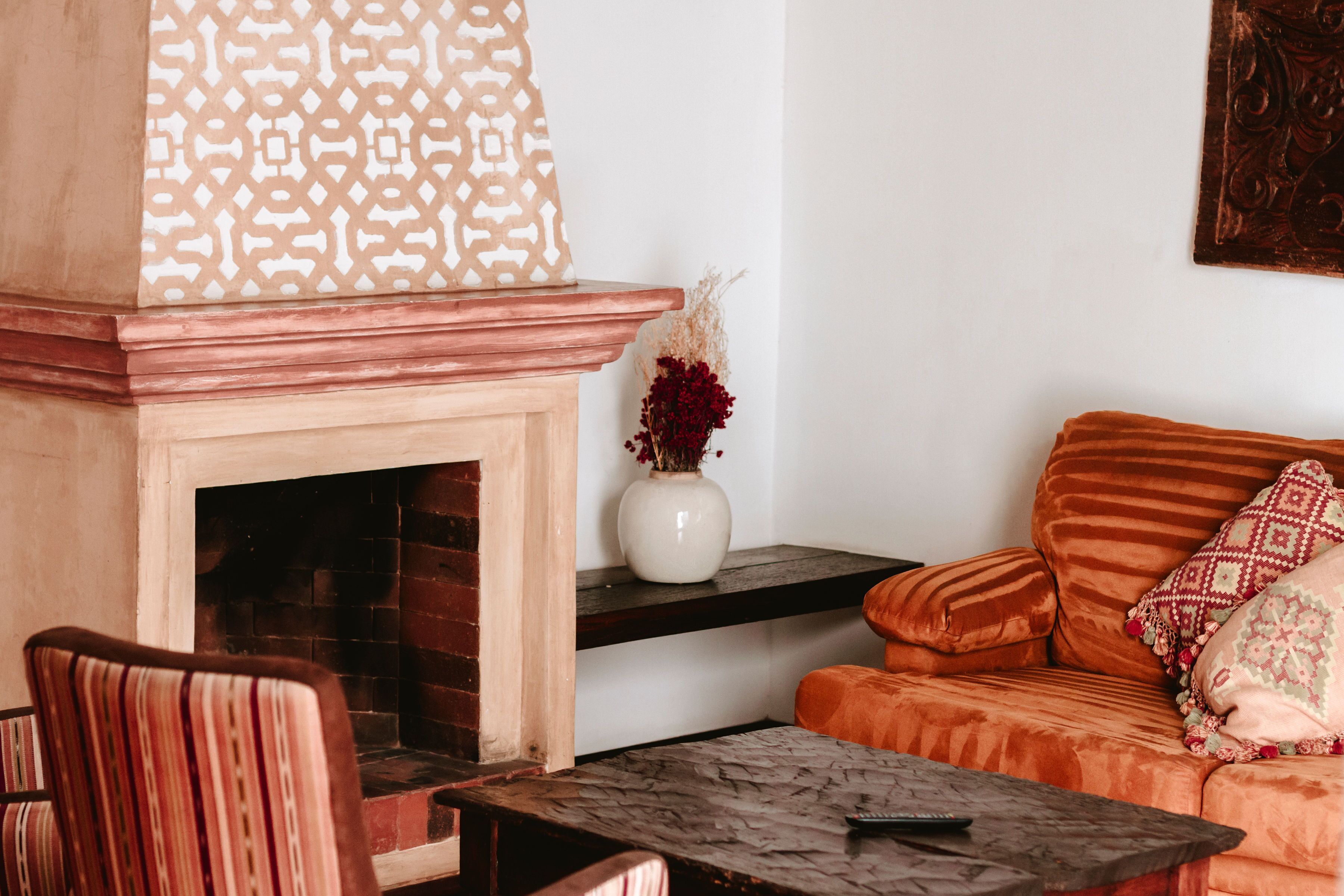 Un salon chaleureux avec une cheminée, un canapé et une table basse.