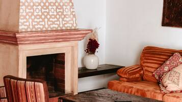 Un salon chaleureux avec une cheminée, un canapé et une table basse.