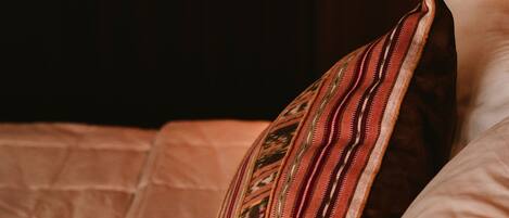 Un lit avec un oreiller à motifs et une couverture matelassée.