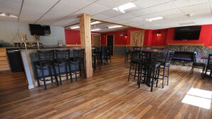 Een restaurant met houten vloeren, een bar en verschillende zithoeken.