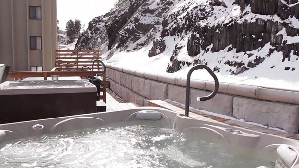 Een jacuzzi met uitzicht op besneeuwde bergen.