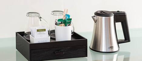 A tray with a coffee maker, a glass container, and a box labeled "ALTHAUS".