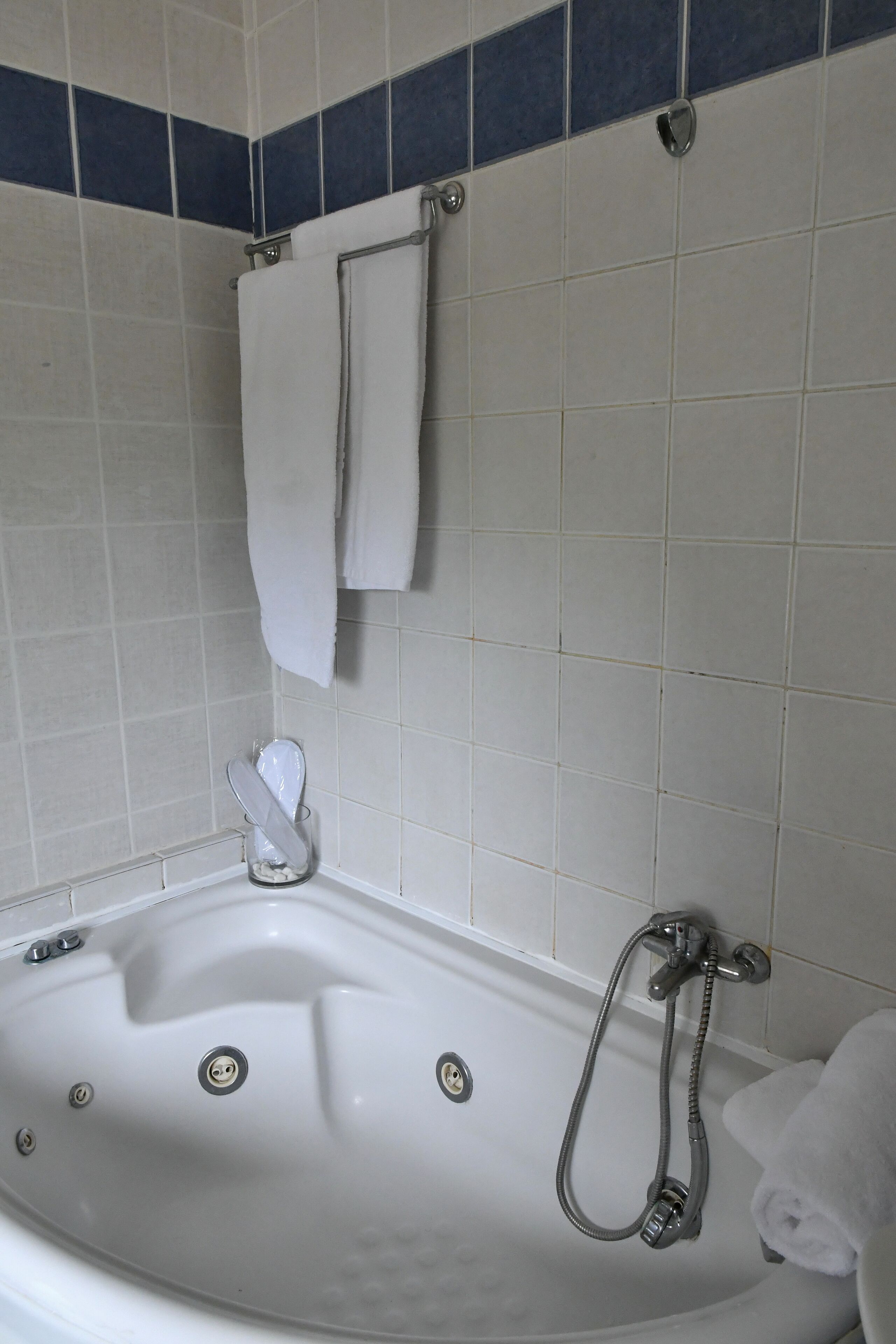 Een badkamer met een bad, een douche en een handdoekrek.