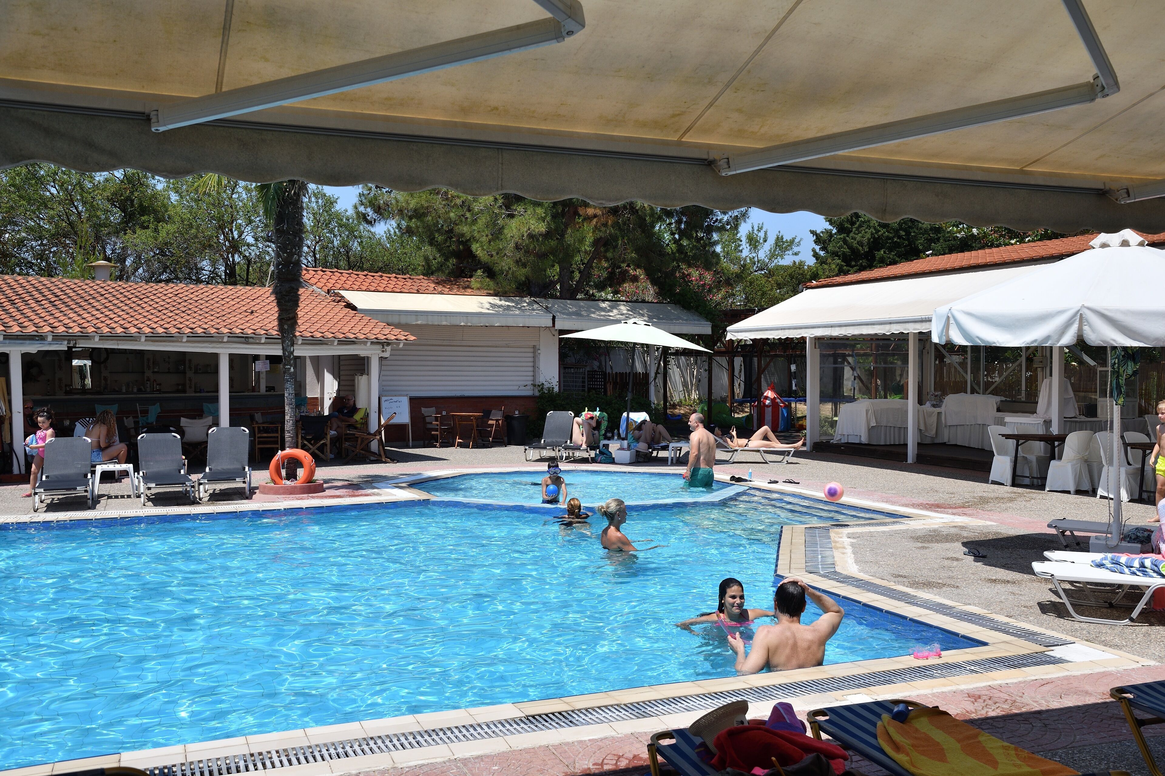 Una piscina al aire libre, sillones reclinables de piscina
