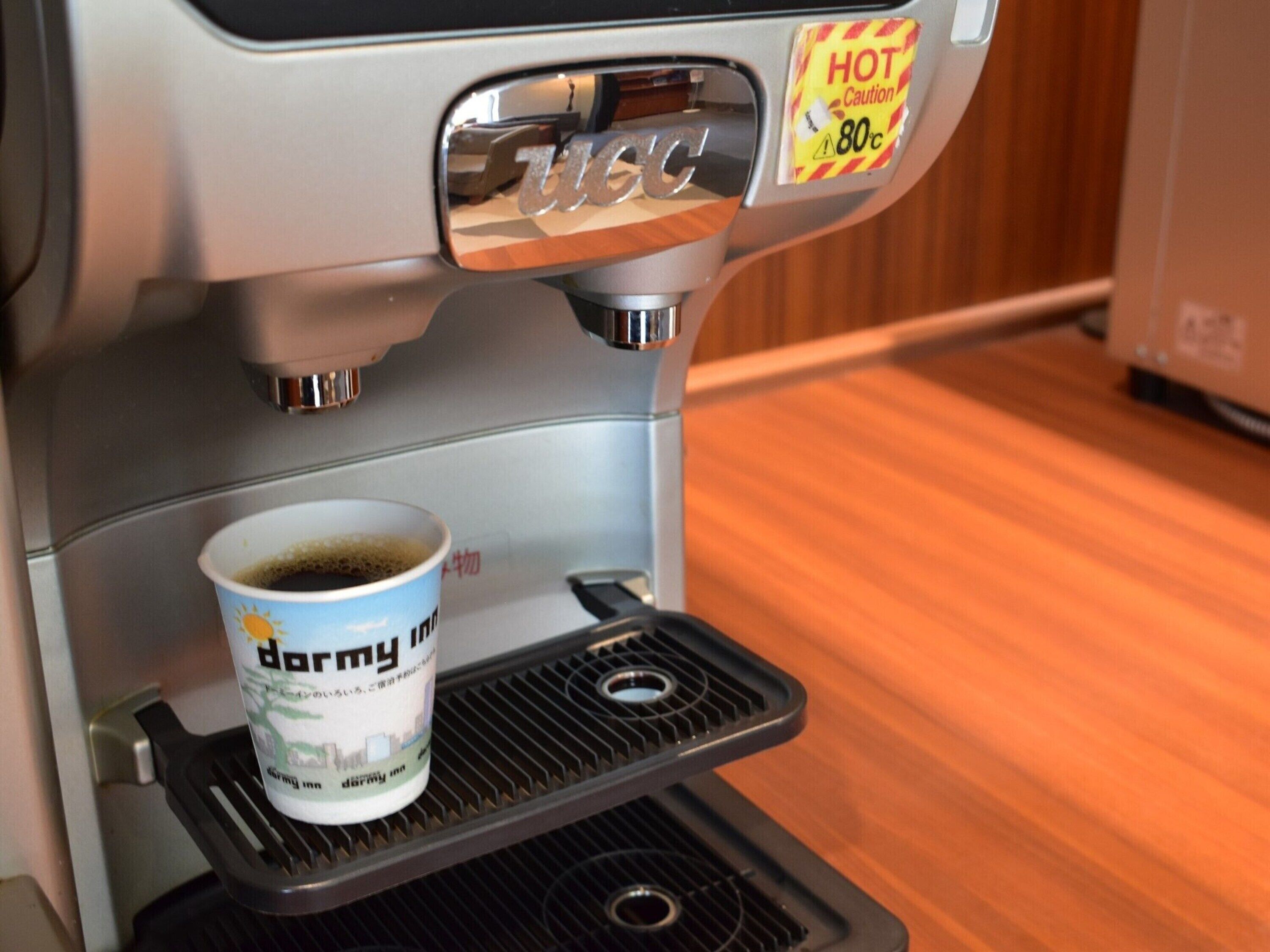 A coffee machine with a cup of coffee on a tray.