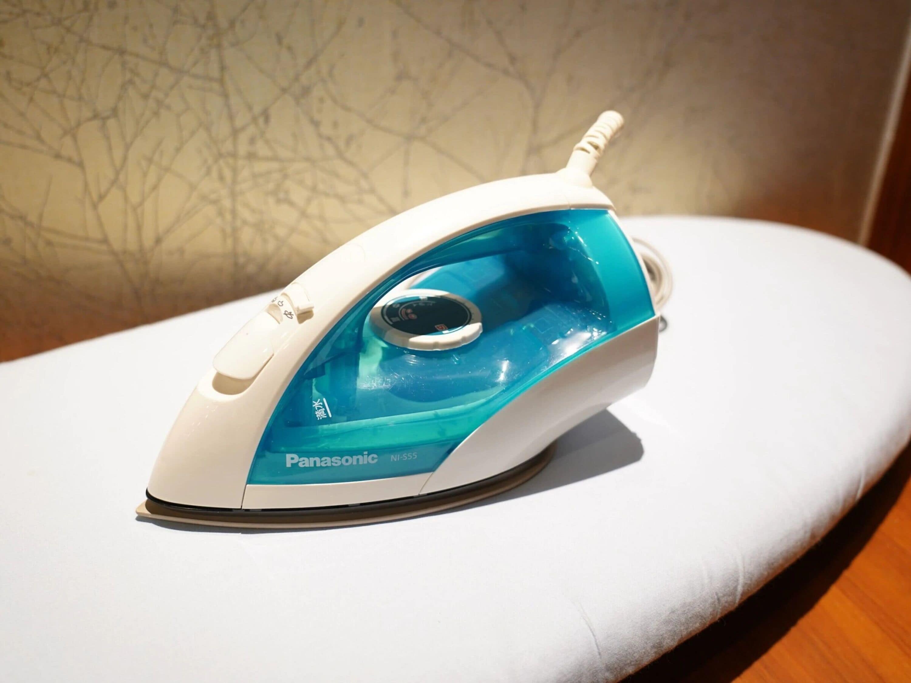 A Panasonic iron with a blue and white design, placed on a white surface.
