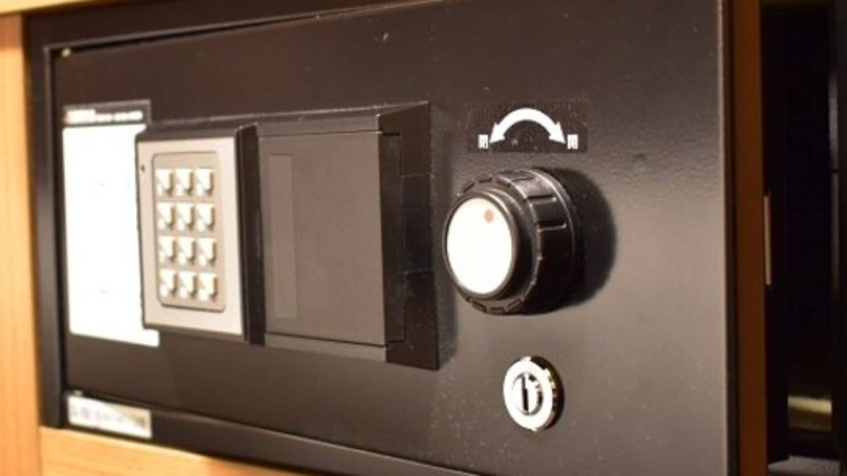 Panel de control con teclado y un botón redondo, probablemente para el acceso a la habitación o seguridad.