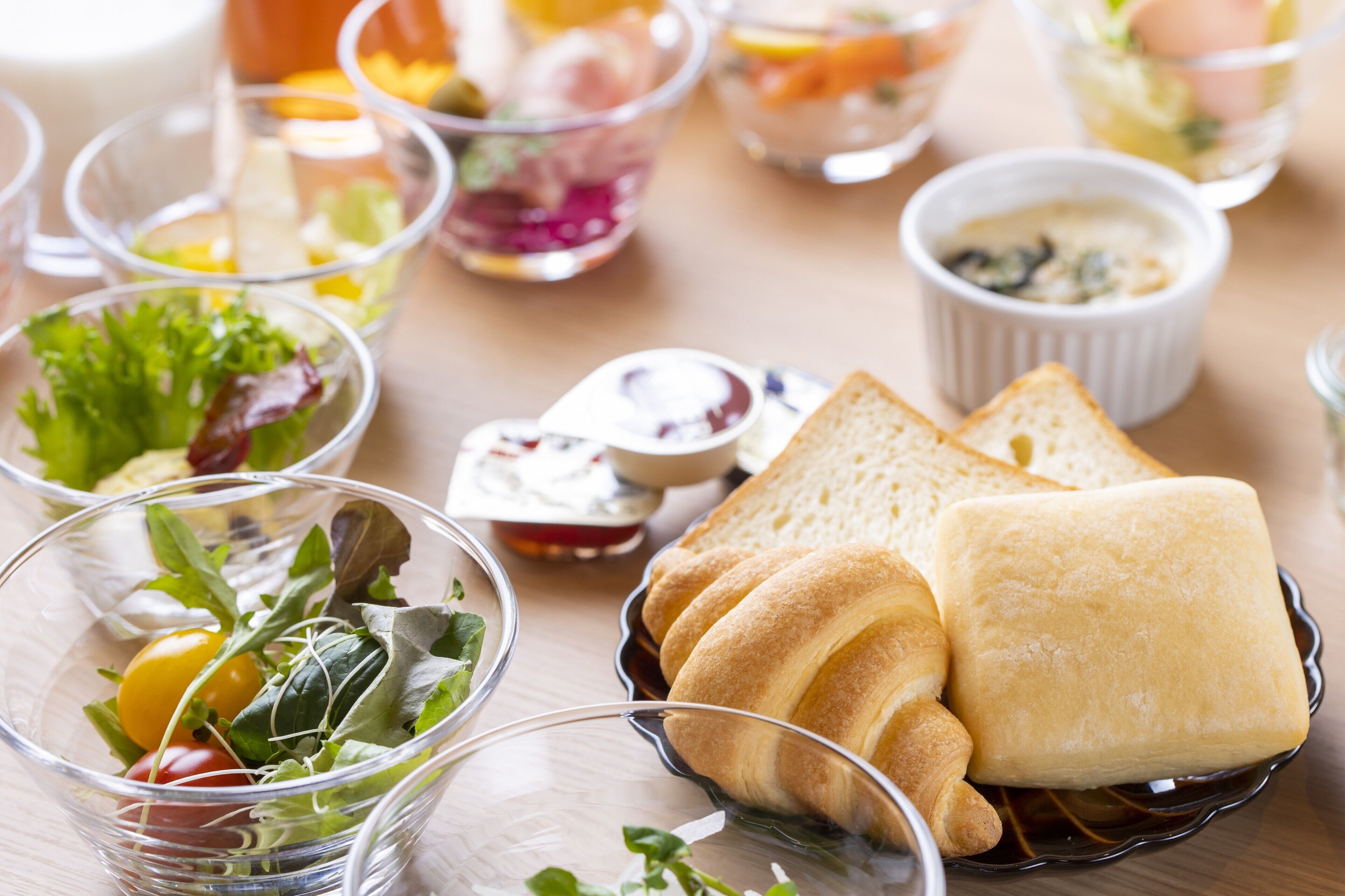 Een tafel met diverse soorten eten, zoals salades, brood en kleine bakjes met dipsauzen.