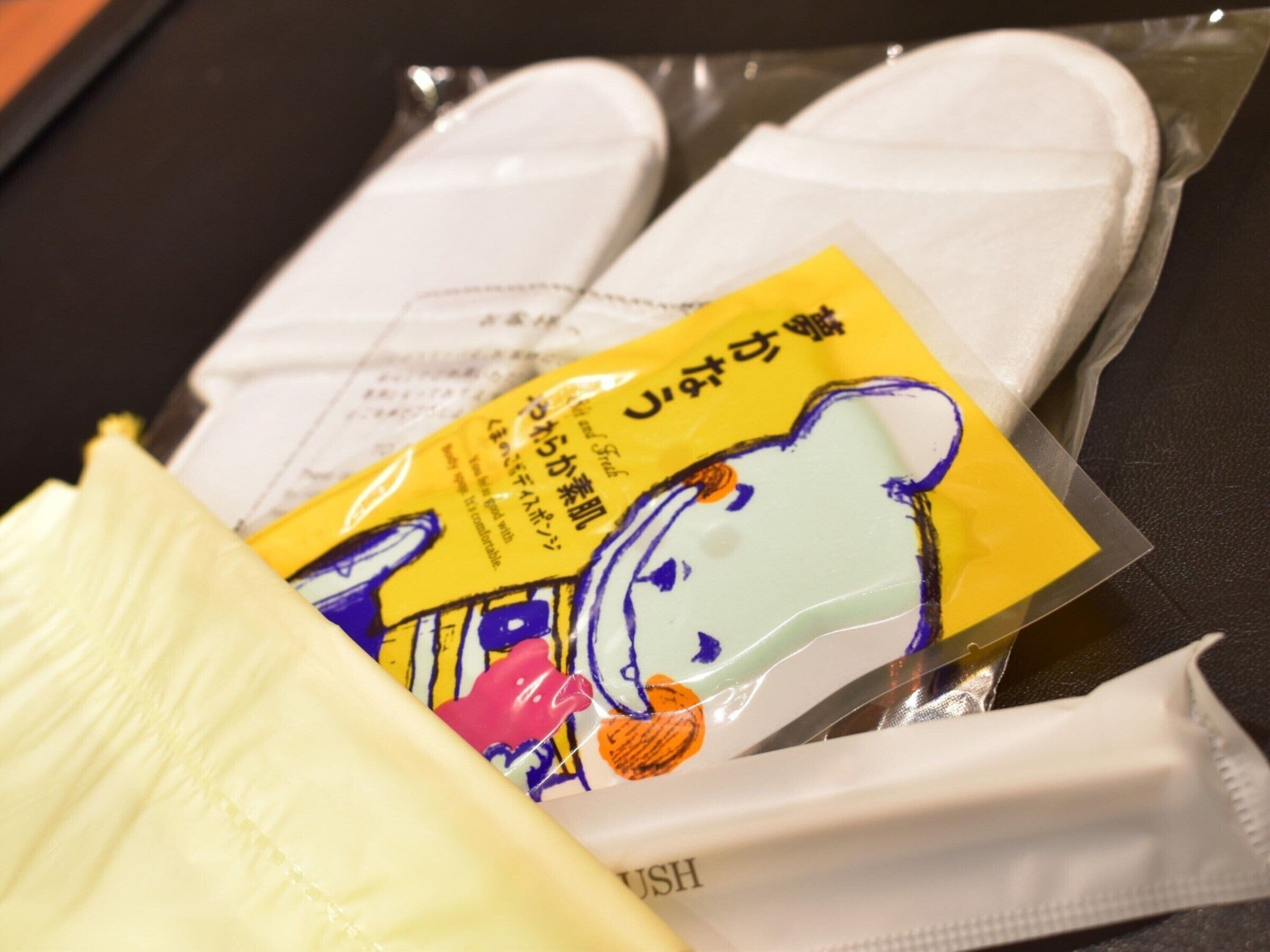 Un emballage orné d’un personnage de dessin animé et de texte en japonais, posé sur une table à côté d’un coussin blanc.