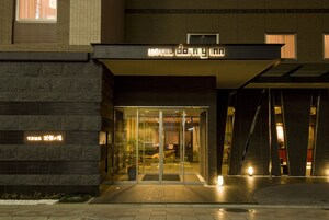 A hotel entrance with a modern design, featuring a glass door and a sign above the entrance.