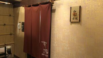 Un bagno femminile con tenda in bambù e un'indicazione che è riservato alle donne.