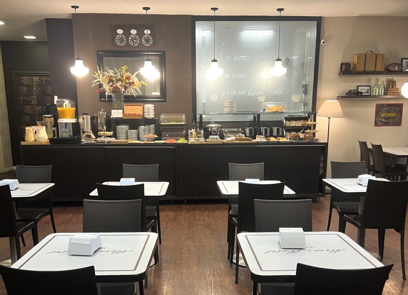 Un restaurant avec un comptoir, des chaises, des tables et un mur orné d’une horloge et d’une enseigne.