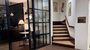 A modern interior with a staircase, a glass door leading to a dining area, and a fire extinguisher on the wall. - Alvear Hotel (Montevideo)