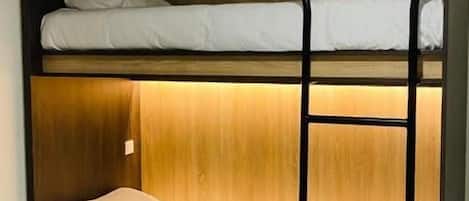 Ein Stockbett mit Holzkopfteil und einer Leiter.