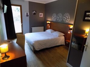 Comfortable retreat with a large bed, two bedside tables, and a functional desk.