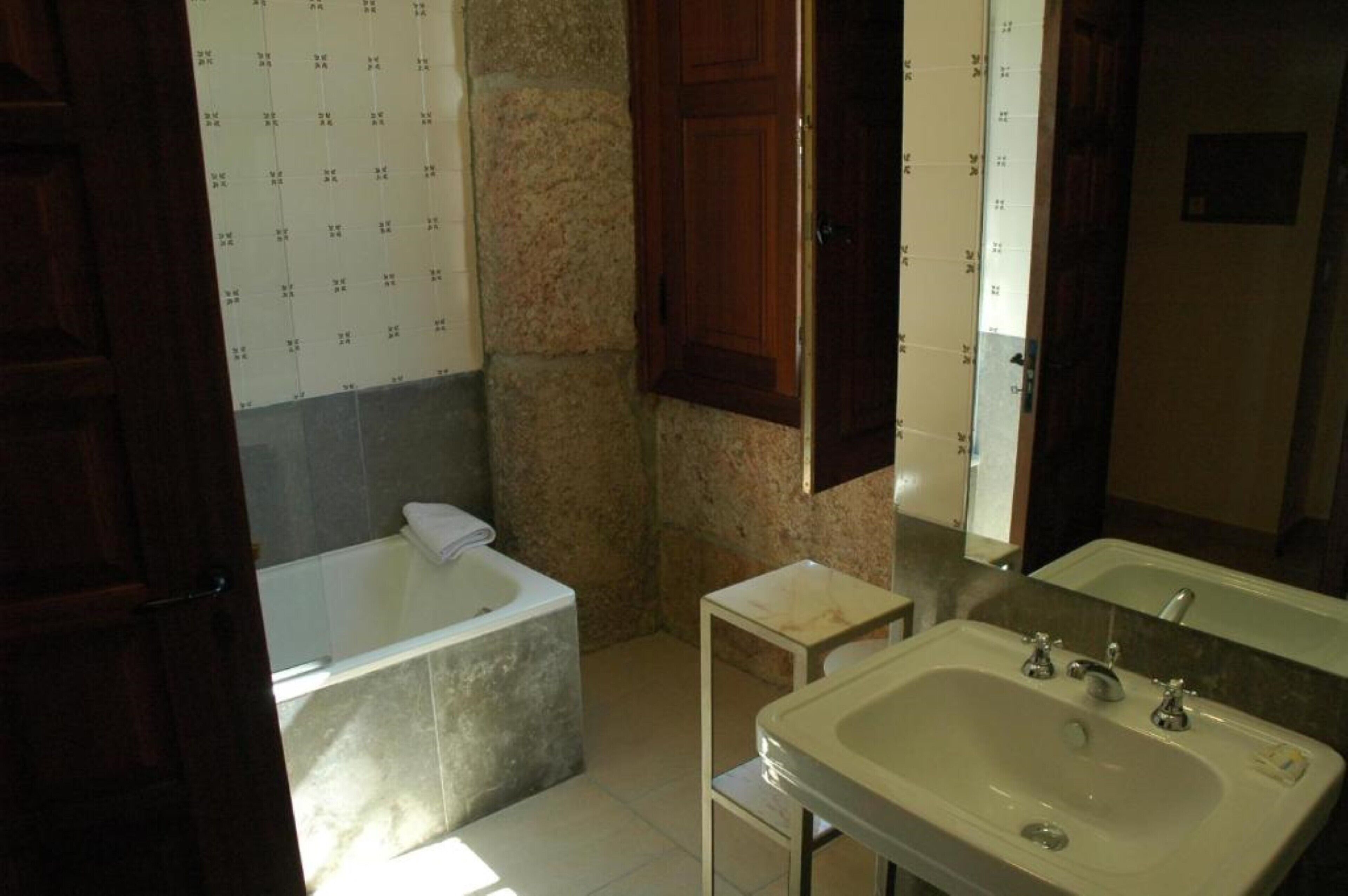 Un baño con bañera, lavabo y espejo.