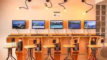 A reception area with multiple computer monitors, wooden chairs, and a sign above the monitors.