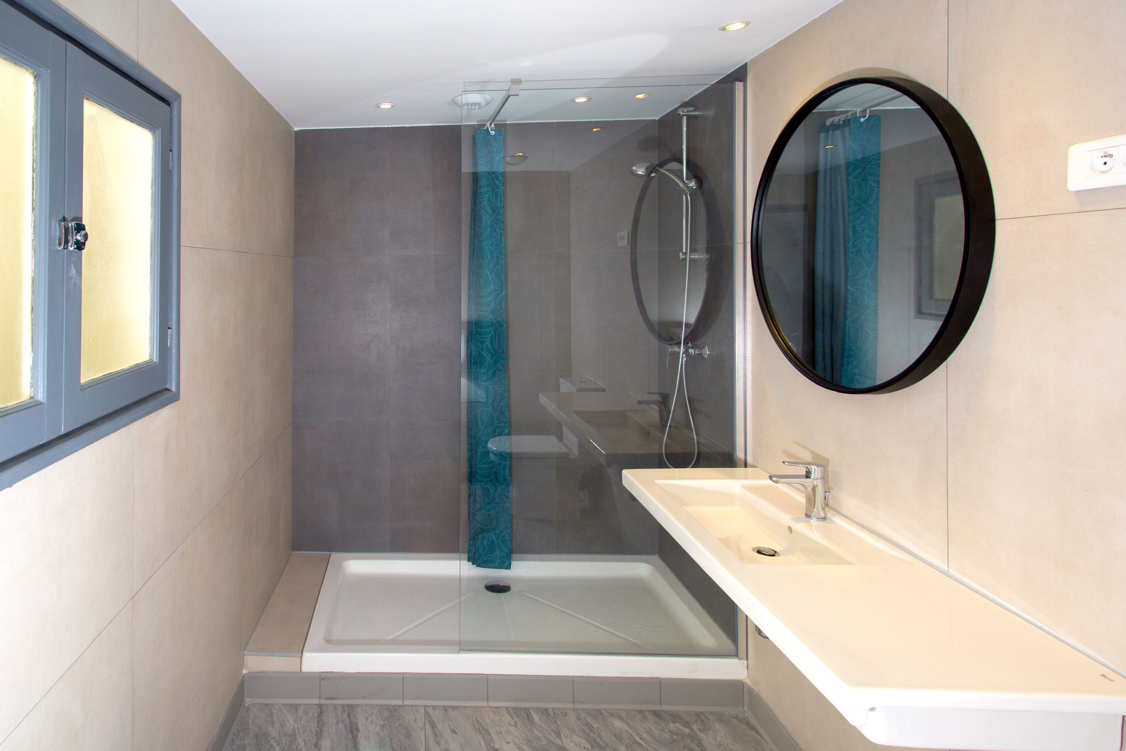 Une salle de bain moderne dotée d’une douche à parois de verre, d’une baignoire sur pied et d’un meuble-lavabo avec un miroir.
