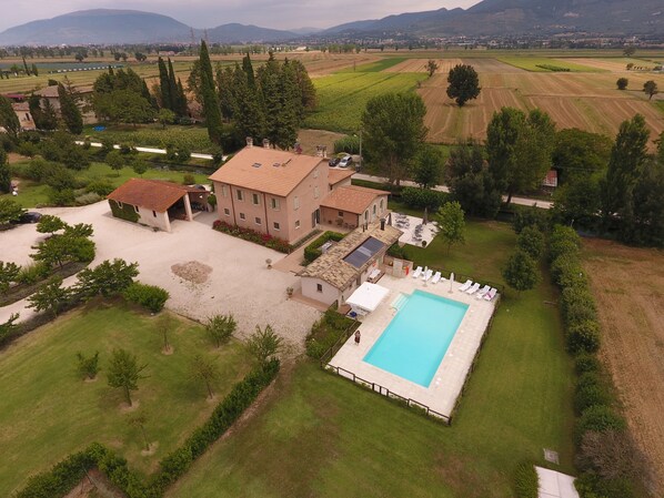 Un vaste domaine comprenant une piscine, plusieurs bâtiments et de vastes étendues de verdure.