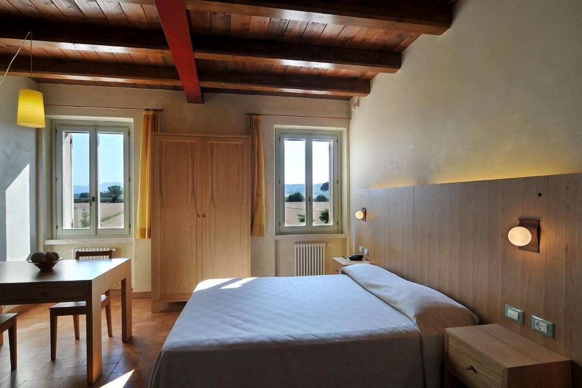 Ein Schlafzimmer mit Bett, Nachttisch und Fenster mit Blick.