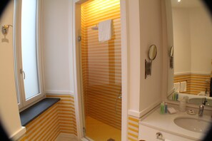 Habitación Confort doble | Baño | Cabezal de ducha tipo lluvia y artículos de higiene personal de diseño