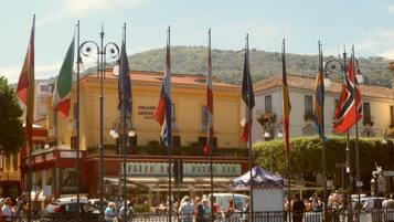 A building with multiple flags, a bar, and a crowd of people.