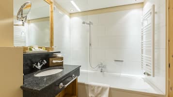 A modern bathroom with a sink, mirror, and shower.