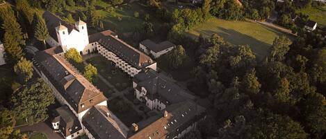 An aerial view of a large, historic building complex with multiple wings and a central courtyard.