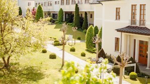 A hotel with a courtyard, multiple buildings, and a church in the background.