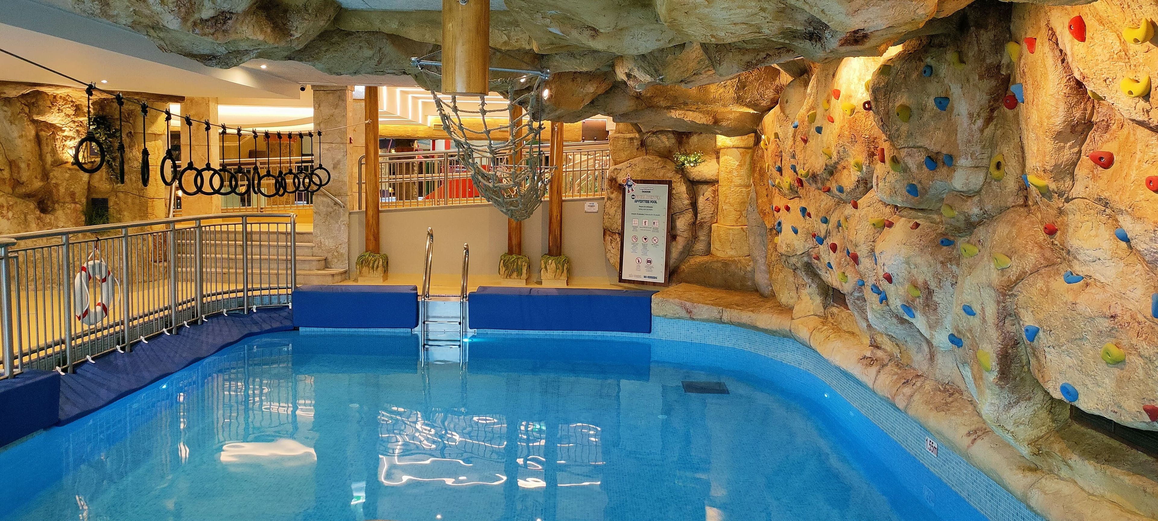 Un espace d’escalade en salle avec une piscine.