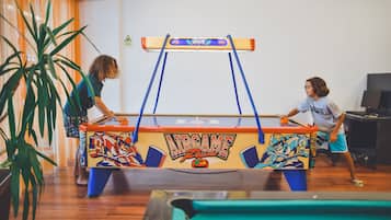 Uma mesa de bilhar com design colorido e um aviso na parede.