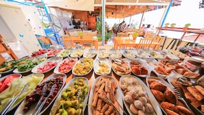 A buffet table with various food items and utensils.