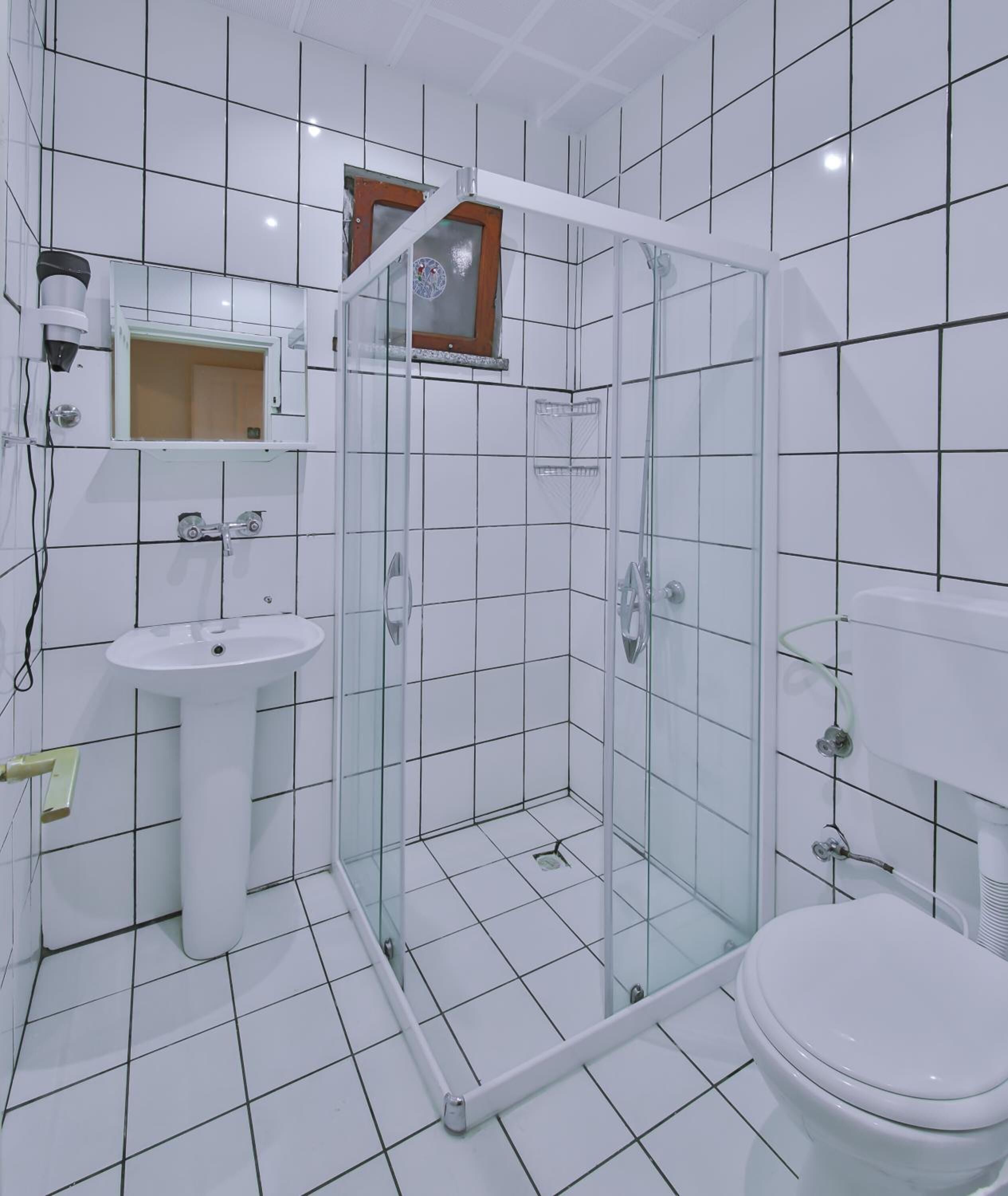 Une salle de bain avec une douche à parois de verre, un lavabo et des toilettes.