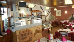 A restaurant interior with wooden decor, a counter with a glass display, and tables set with pink napkins. - Hotel delle Alpi (Sondalo)