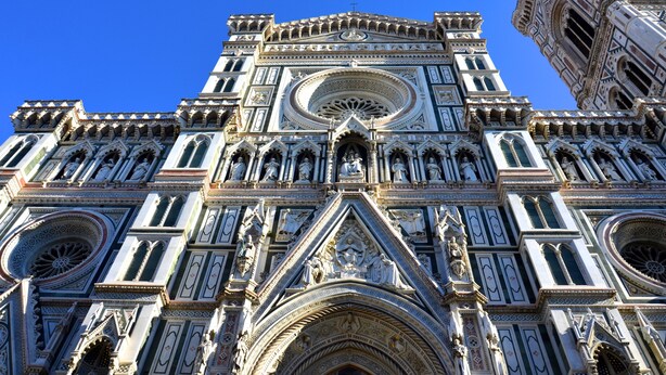 A detailed view of a Gothic-style cathedral with intricate architectural elements and statues.
