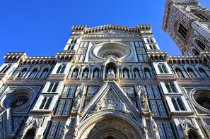 Une vue détaillée d’une cathédrale de style gothique, avec des éléments architecturaux complexes et des statues.